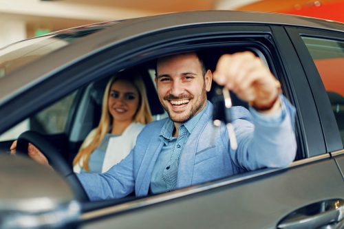 Young couple holding the keys of a new car