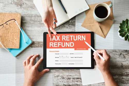 individual reviewing a tax return refund form on a tablet