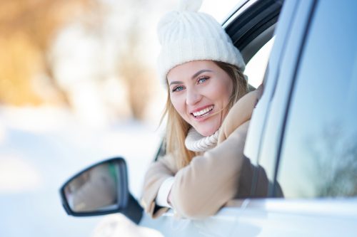 lady in white hat leaning out of car window