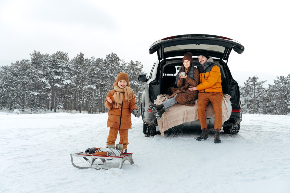 family with vehicle in snow