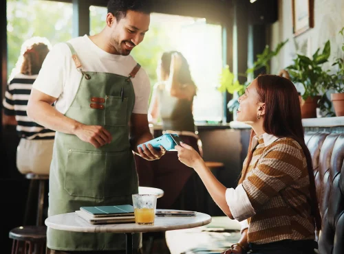 Happy people, customer and waiter with pos machine in coffee shop for credit card payment.